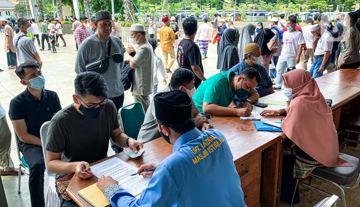 <p>Petugas menerima pembayaran zakat fitrah dari umat muslim di Masjid Istiqlal, Jakarta, Jumat (29/4/2022). Panitia Zakat Masjid Istiqlal mulai membuka layanan pembayaran zakat fitrah dengan pembayaran senilai Rp 50 ribu atau 3,5 liter beras. (Liputan6.com/Faizal Fanani)</p>