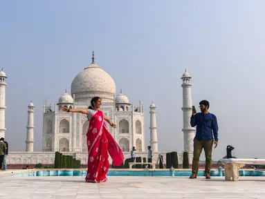 Turis mengunjungi Taj Mahal di Agra, India pada Senin (21/9/2020). Taj Mahal kembali dibuka untuk umum hari ini, Senin (21/9), dalam gerakan simbolis seperti biasa, bahkan ketika India tampaknya akan mengambil alih AS sebagai pemimpin global dalam infeksi Virus Corona COVID-19. (Sajjad HUSSAIN/AFP)