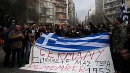 Ratusan Petani membawa bendera Yunani bertuliskan "Germany pay us back now" selama protes petani terhadap perubahan peraturan pensiun yang direncanakan di luar Kementerian Pertanian, Athena, Yunani, Jumat (12/2). (REUTERS/Alkis Konstantinidis)	