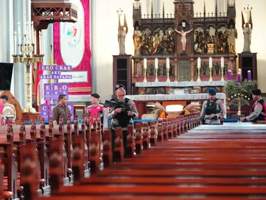 Polisi dari berbagai unsur melakukan sterilisasi di Katedral Bunda Maria Diangkat ke Surga atau Gereja Katedral Jakarta, Selasa (23/12/2025). Tampak dalam foto, personel dari regu penjinak bom kepolisian Indonesia memeriksa deretan kursi di dalam gereja selama operasi keamanan menjelang perayaan Natal di Katedral Bunda Maria Diangkat ke Surga atau Gereja Katedral Jakarta, Selasa 23 Desember 2025. (AP Photo/Tatan Syuflana)