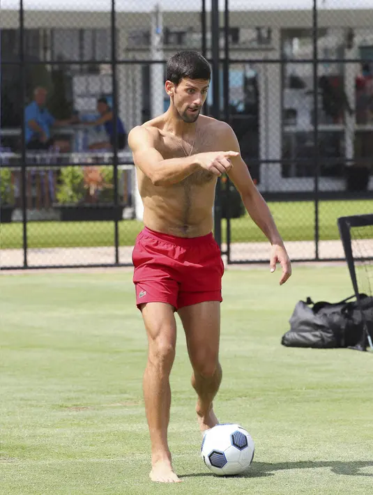 Petenis asal Serbia, Novak Djokovic menggiring bola saat bermain sepakbola bersama timnya jelang bertanding melawan Cristian Garin dari Chile pada hari keenam turnamen tenis ATP Cup di Brisbane, Australia, Rabu (8/1/2020). (AP Photo/Tertius Pickard)