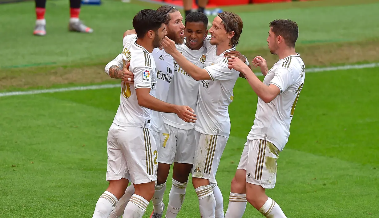 Para pemain Real Madrid merayakan gol yang dicetak oleh Sergio Ramos ke gawang Athletic Bilbao pada laga La liga di Stadion San Mames, Minggu (5/7/2020). Real Madrid menang 1-0 atas Athletic Bilbao. (AFP/Ander Gillenea)