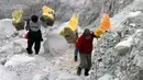 Dua orang penambang sulfur mengangkut hasil tambang keluar kawasan kawah Gunung Ijen, Jawa Timur, (20/10/2014). (Liputan6.com/Helmi Fithriansyah)