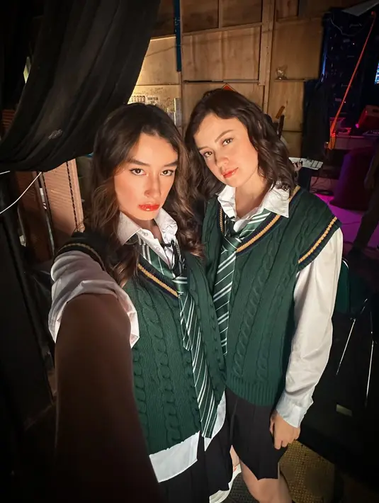 Kimberly dan Natasha Ryder tampil kembar jadi Slytherin's sister. Kedua kenakan kemeja putih dan rok mini yang dipadukan dengan vest dan dasi hijau [@natasharyder]