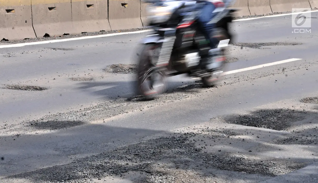 Pengendara motor melintasi jalan berlubang di Gunung Sahari, Jakarta, Selasa (29/1). Sedikitnya terdapat 8 titik jalan rusak dan berlubang di sepanjang Jalan Gunung Sahari berdiameter hingga 10 cm dengan kedalaman 10 cm. (Merdeka.com/Iqbal S. Nugroho)