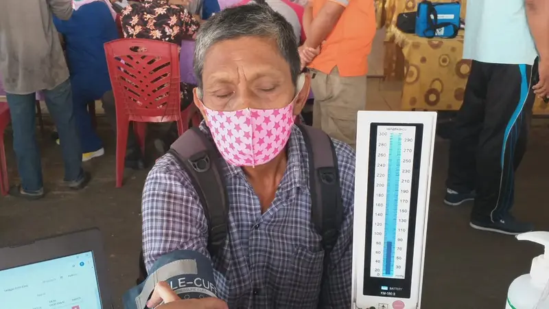 Seorang pedagang di Pasar Raya Padang sedang melakukan cek kesehatan d=sebelum divaksin. (Liputan6.com/ Novia Harlina)