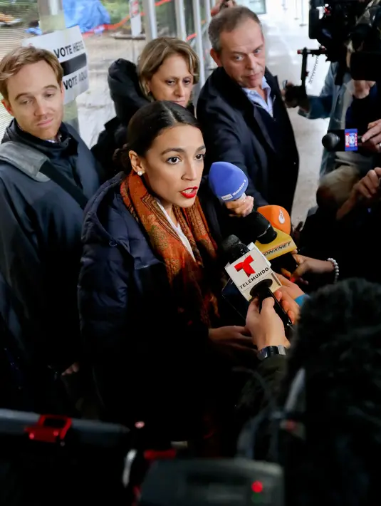 Calon anggota kongres AS Alexandria Ocasio-Cortez menjawab pertanyaan wartawan usai pemungutan suara di komunitas Parkchester, Bronx, New York, Selasa (6/11). Ocasio-Cortez mengalahkan seorang profesor dari Partai Republik. (AP Photo/Bebeto Matthews)