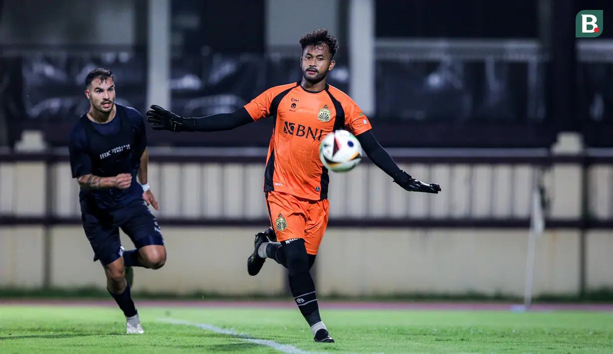 Kiper Bhayangkara FC, Aqil Savik (kanan) berusaha mengontrol bola saat laga uji coba melawan Suwon FC di Stadion PTIK, Jakarta, Senin (12/02/2024). (Bola.com/Bagaskara Lazuardi)