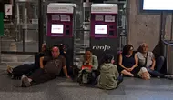 Para pelancong duduk dan berbaring di lantai saat bersiap untuk bermalam di Stasiun Cordoba Spanyol, selama pemadaman listrik massal yang memengaruhi seluruh Semenanjung Iberia dan Prancis selatan, di Cordoba pada 28 April 2025. (dok. JAVIER SORIANO / AFP)