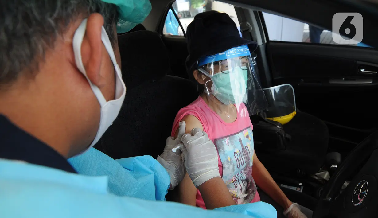 Paramedis menyuntikkan vaksin COVID-19 kepada lansia saat vaksinasi secara drive-thru di ICE BSD, Tangerang, Banten, Sabtu (13/3/2021). Sebanyak 5.000 masyarakat umum, lanjut usia (lansia), dan pengemudi ojek online (ojol) divaksin COVID-19 pada hari ini dan besok. (merdeka.com/Arie Basuki)