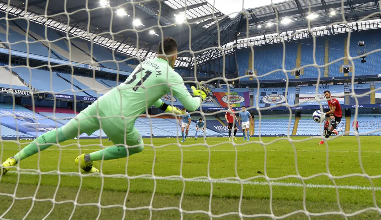 Pemain Manchester United Bruno Fernandes (kanan) mencetak gol ke gawang Manchester City yang dijaga Ederson pada pertandingan Liga Inggris di Etihad Stadium, Manchester, Inggris, Minggu (7/3/2021). Manchester United mempermalukan Manchester City dengan skor 2-0. (Peter Powell/Pool via AP)
