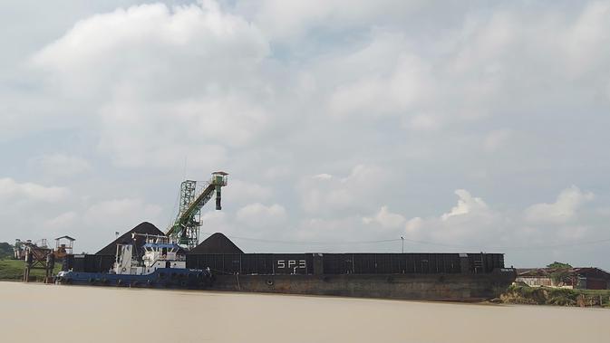 Sebuah kapal tongkang memuat batu bara di tubir Sungai Batanghari di KCB Muarajambi. Tak hanya mengancam situs candi, stockpile batu bara juga merusak promosi wisata. (Liputan6.com/Gresi Plasmanto)