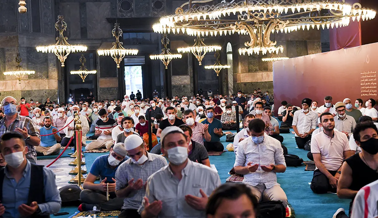 Jemaah mengenakan masker dan menerapkan jaga jarak untuk menghindari penularan COVID-19 saat melaksanakan salat Idul Adha di Hagia Sophia, Istanbul, Turki, Jumat (31/7/2020). Ini merupakan salat Idul Adha pertama di Hagia Sophia setelah dialihfungsikan dari museum menjadi masjid. (Pool via AP)