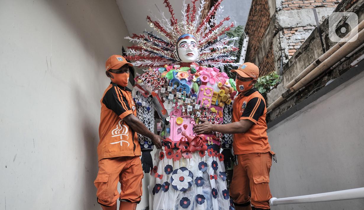 Petugas PPSU membawa ondel-ondel dari limbah plastik di Kantor Kelurahan Kemayoran, Jakarta, Senin (3/8/2020). Limbah plastik dikumpulkan dari wilayah setempat. (merdeka.com/Iqbal S. Nugroho)