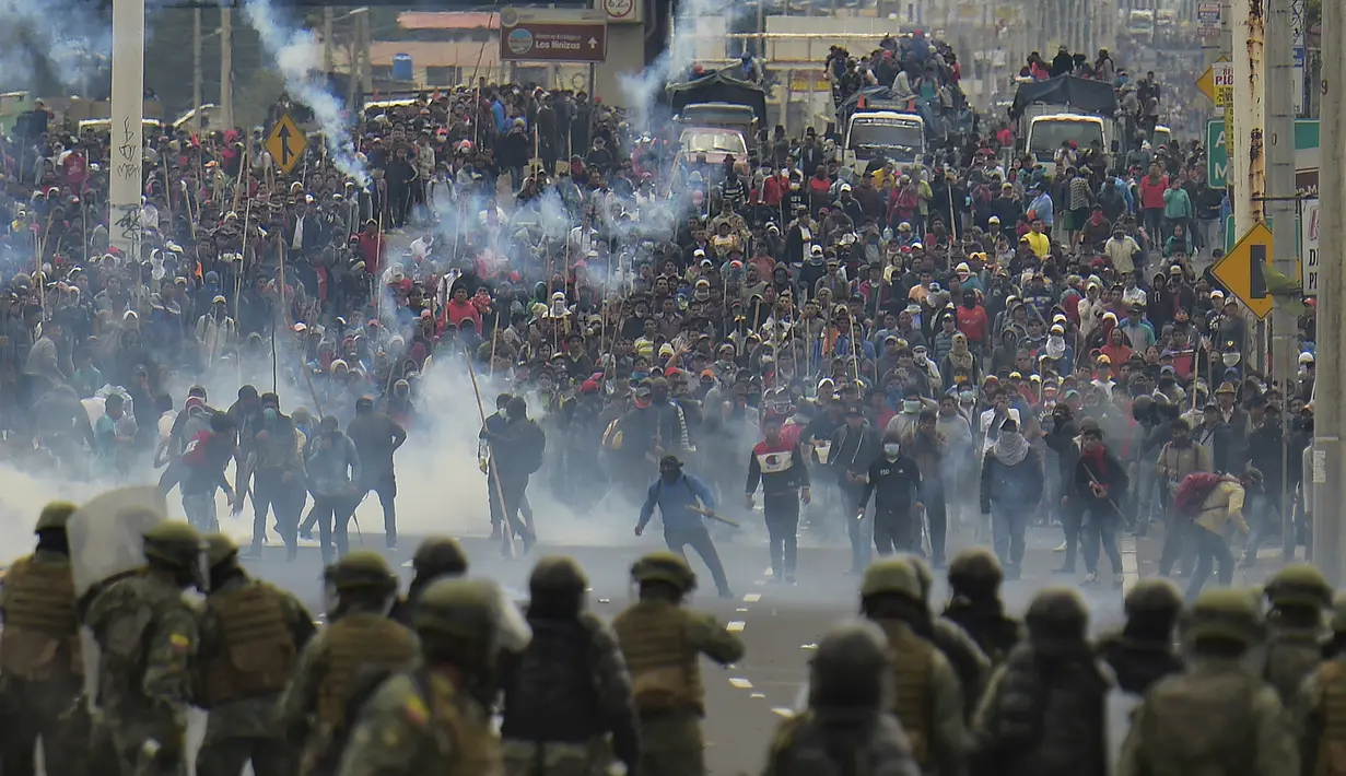 Demonstran saat bentrok dengan polisi anti huru hara di Quito (7/10/2019). Massa demonstran di Ekuador juga menyerbu gedung parlemen dalam lanjutan aksi protes kenaikan harga BBM hingga 100 persen. (AFP Photo/Rodrigo Buendia)