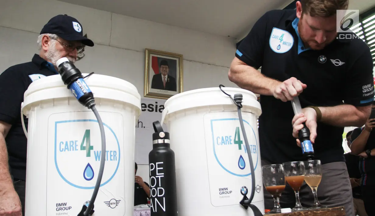 Field Director Waves for Water, Rob Mcqueen dan BMW Clubs International Council George Nyktas, menjelaskan cara kerja filter Care4Water di RPTRA Krendang, Tambora, Jakarta Barat, Minggu (28/4/2019). Care4Water dilengkapi dengan membran 0,1 micron yang menyaring kotoran. (Liputan6.com/Ismail)