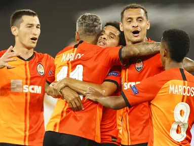 Para pemain FC Shakhtar Donetsk merayakan gol yang dicetak oleh Taison ke gawang FC Basel pada perempat final di Veltins Arena, Selasa (11/8/2020). Shakhtar Donetsk menang dengan skor 4-1. (Wolgang Rattay/Pool Photo via AP)