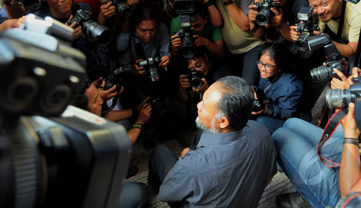 Bambang Widjojanto duduk di tangga saat menjawab pertanyaan wartawan terkait kedatangannya di kantor Bareskrim, Jakarta, Selasa (24/2/2015).(Liputan6.com/Andrian M Tunay)