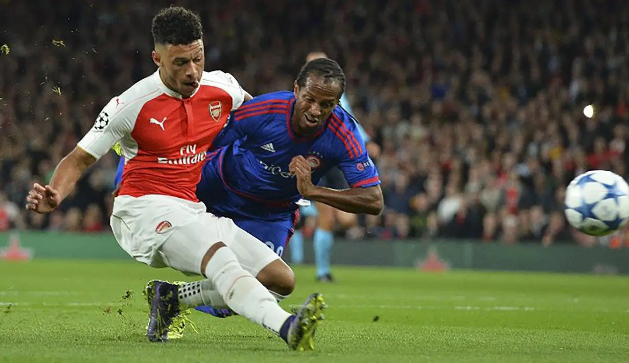 Pemain Arsenal, Alex Oxlade-Chamberlain berusaha melewati pemain Olympiacos, Leandro Salino pada laga Liga Champions di Stadion Emirates, Inggris, Rabu (30/9/2015). (AFP Photo/Glyn Kirk)