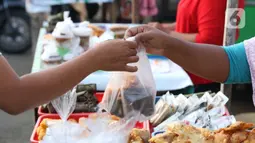 Warga melakukan aktivitas jual beli makanan untuk berbuka puasa (takjil) di kawasan Jalan Panjang, Jakarta, Selasa (5/5/2020). Pandemi virus COVID-19 dan pelaksanaan Pembatasan Sosial Berskala Besar (PSBB) berimbas pada sepinya pembeli takjil di kawasan tersebut. (Liputan6.com/Helmi Fithriansyah)
