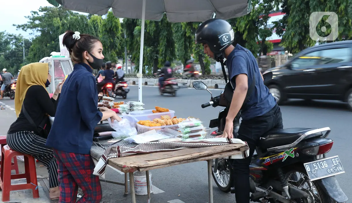 Warga memilih makanan untuk berbuka puasa (takjil) di kawasan Jalan Panjang, Jakarta, Selasa (5/5/2020). Pandemi virus COVID-19 dan pelaksanaan Pembatasan Sosial Berskala Besar (PSBB) berimbas pada sepinya pembeli takjil di kawasan tersebut. (Liputan6.com/Helmi Fithriansyah)
