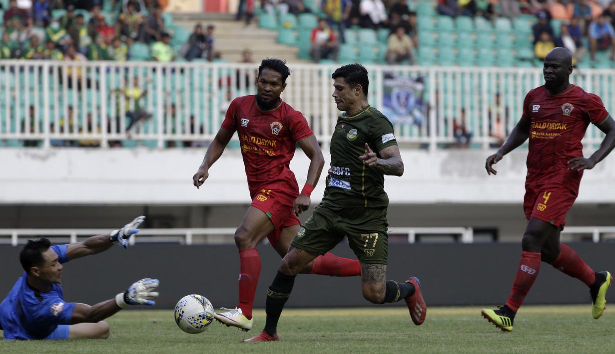 Gelandang Tira Persikabo, Ciro Henrique, berusaha melewati kiper Kalteng Putra, Dimas Galih, pada laga Shopee Liga 1 di Stadion Pakansari, Bogor, Jumat (26/7). Tira Persikabo menang 5-2 atas Kalteng. (Bola.com/Yoppy Renato)