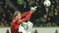 Pemain Wolfsburg, Dante berebut bola dengan kiper KAA Gent, Matz Sels pada leg kedua babak 16 besar  Liga Champion di di Volkswagen Arena, Wolfsburg, Rabu (9/3/2016) dini hari WIB. (AFP/Odd Andersen)