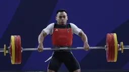 Lifter Eko Yuli melakukan angkatan saat SEA Games 2019 cabang angkat besi nomor 61 kg di Stadion Rizal Memorial, Manila, Minggu (1/12). Dirinya meraih emas dengan total angkatan 309 kg. (Bola.com/M Iqbal Ichsan)