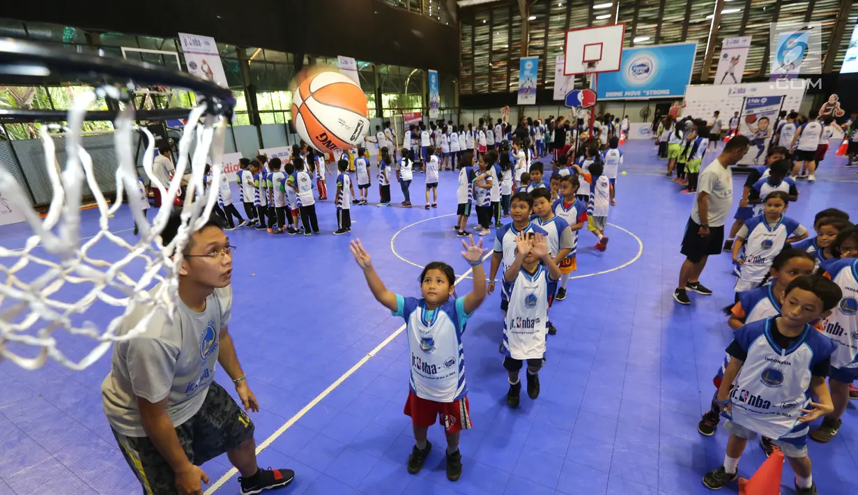 Anak-anak memasukan bola basket ke dalam keranjang pada program Junior NBA Indonesia di Cilandak, Jakarta, Sabtu (24/3). Peserta diberikan pelatihan tentang dasar-dasar olahraga basket. (Liputan6.com/Fery Pradolo)
