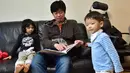 Kim Jin-Sung membacakan buku untuk putrinya Na-Eun dan putranya Won-Woo di apartemen mereka di Seoul. Sebuah ide yang tak biasa dimana anak sehari-hari dapat diurus oleh seorang pria yang merupakan tanggung jawab wanita. (AFP PHOTO/JU)