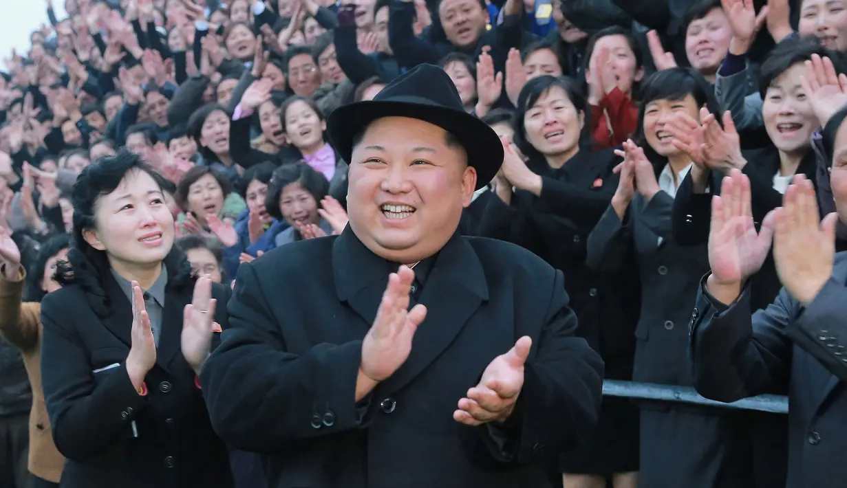 Pemimpin Korea Utara Kim Jong-Un tersenyum sambil bertepuk tangan saat mengunjungi Universitas Guru Pyongyang yang baru direnovasi di Pyongyang (17/1). (KCNA VIA KNS/AFP)