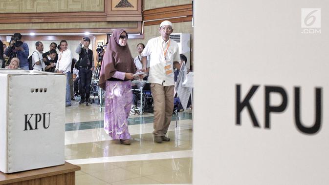 Petugas menuntun penyandang disabilitas saat akan melakukan pencoblosan dalam simulasi Pemilu di Jakarta, Kamis (14/2). Simulasi ini diikuti oleh ratusan penyandang disabilitas. (Liputan6.com/Faizal Fanani)