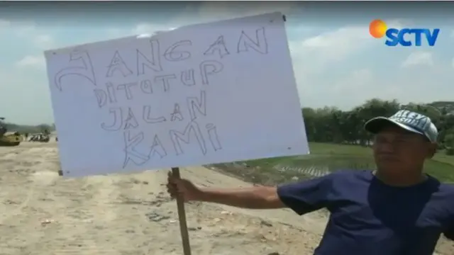 Warga juga membawa poster kertas bertuliskan ungkapan protes atas ditutupnya akses jalan kampung mereka yang membentang utara ke selatan