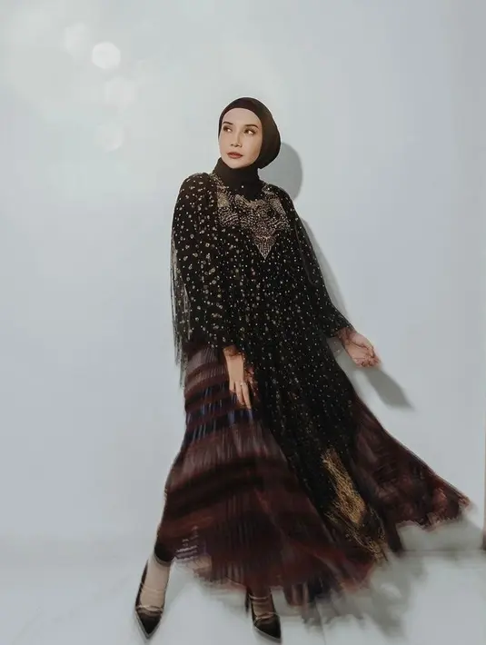 Tampil elegan di momen Idul Fitri dengan kaftan nuansa hitam dan emas seperti yang dikenakan Zaskia Sungkar ini. Untuk hijab, kamu bisa kenakan warna senada dengan model ikat. (Instagram/zaskiasungkar15).