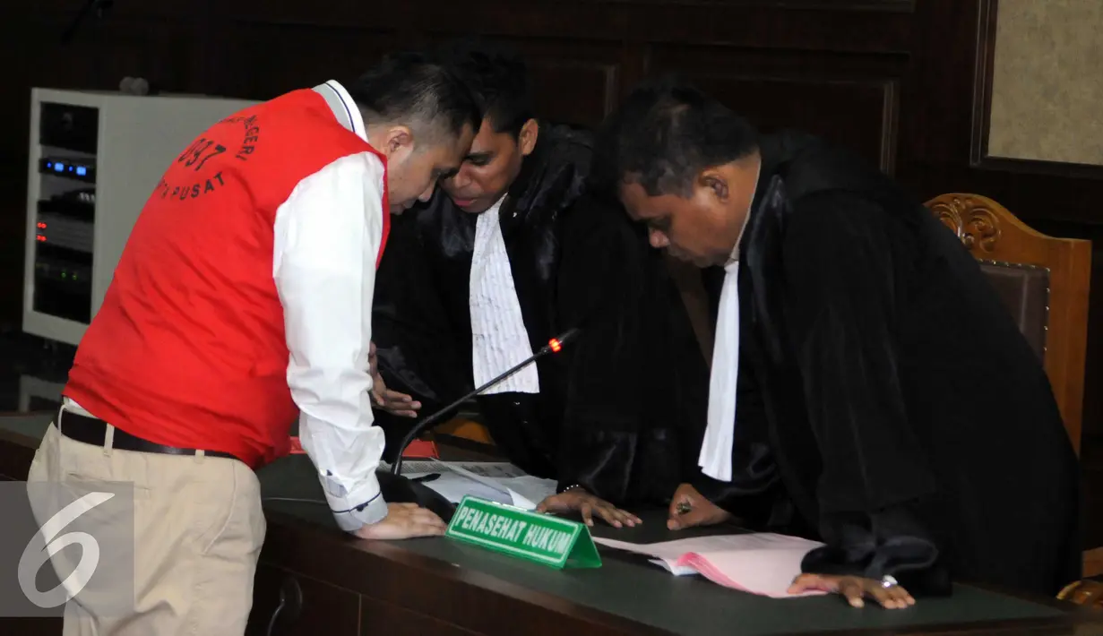Ivan Haz berdiskusi dengan penasehat hukumnya saat menjalani sidang perdana dugaan penganiayaan PRT, Jakarta, Rabu (8/6). Dengan kasusnya ini, Ivan terancam lebih dari lima tahun ‎penjara. (Liputan6.com/Helmi Afandi)