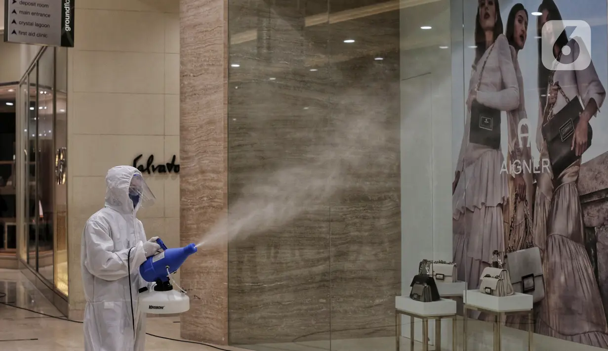 Petugas menyemprotkan cairan disinfektan di Senayan City, Jakarta, Selasa (9/6/2020). Senayan City siap menyambut pengunjung kembali pada 15 Juni 2020 dengan menerapkan berbagai protokol pencegahan COVID-19 seperti pengecekan suhu tubuh sensor tanpa sentuh untuk lift. (Liputan6.com/Johan Tallo)