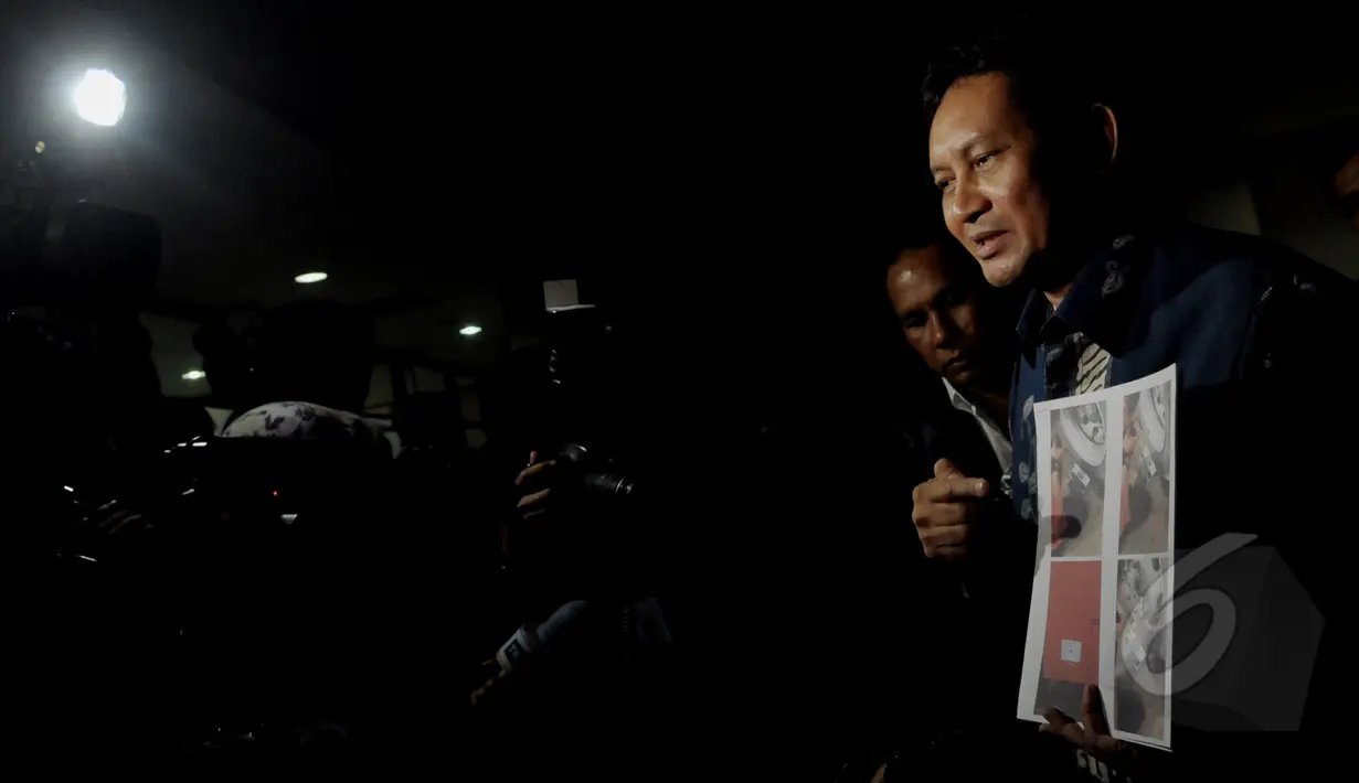 Terdakwa kasus korupsi pengadaan bus TransJakarta, Udar Pristono menunjukan bukti dokumentasi penimbangan ban bus Transjakarta usai menjalani sidang perdana pembacaan dakwaan di Pengadilan Tipikor Jakarta, Senin (13/4/2015). (Liputan6.com/Andrian M Tunay)