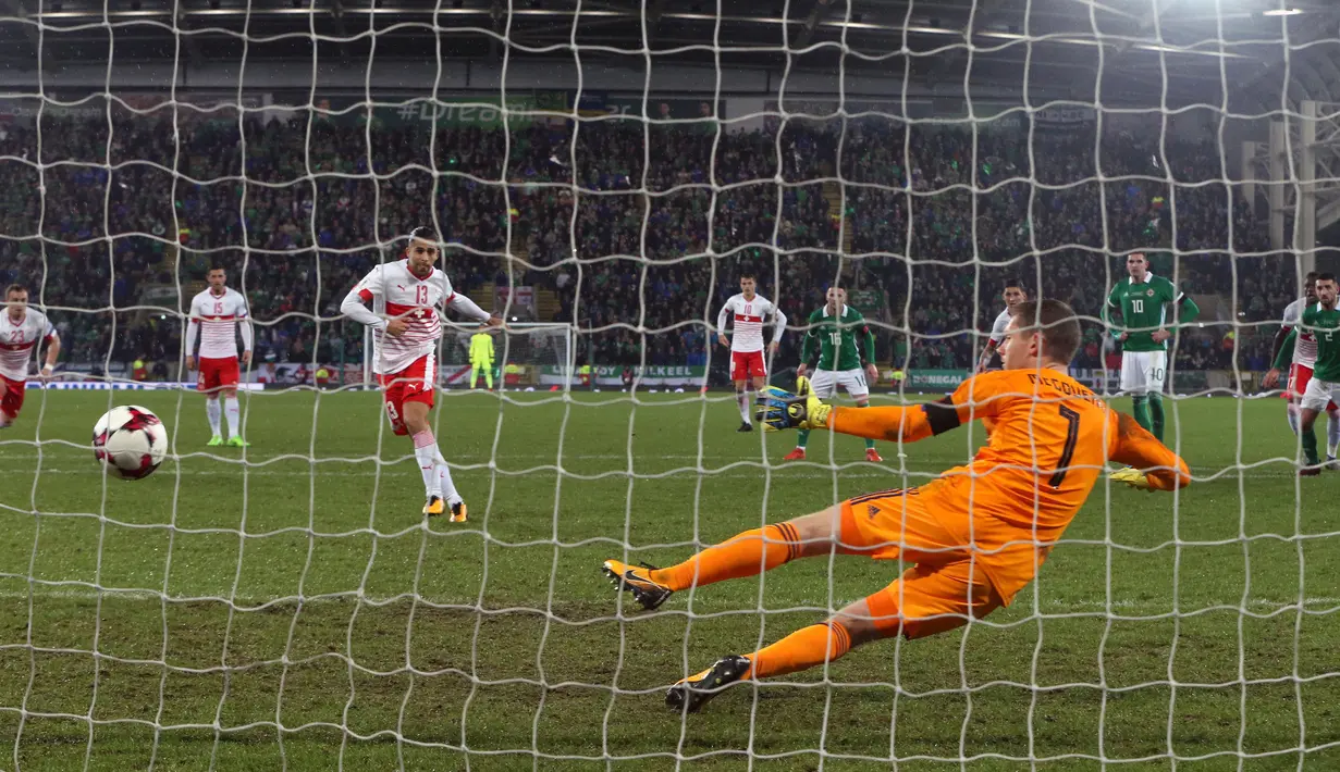Pemain Swiss, Ricardo Rodriguez berhasil mencetak gol lewat penalti ke gawang Irlandia Utara dalam leg pertama playoff Piala Dunia 2018  di Windsor Park, Jumat (10/11). Bermain di kandang lawan, Swiss meraih kemenangan tipis 1-0. (Niall Carson/PA via AP)