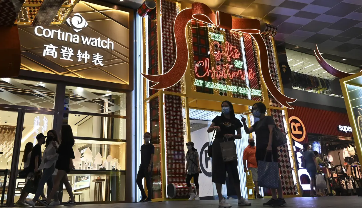 Orang-orang berjalan melewati dekorasi lampu Natal di luar pusat perbelanjaan di sepanjang kawasan Orchard road di Singapura, Selasa (8/12/2020). Mengusung tema Love This Christmas, acara tahun ini lebih sunyi karena aktivitas jalanan dibatasi di tengah pandemi Covid-19. (ROSLAN RAHMAN / AFP)