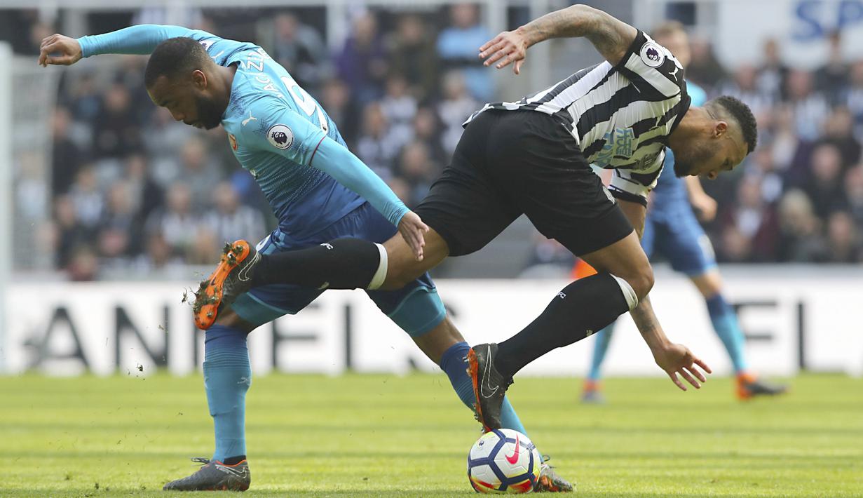 Aksi pemain Arsenal, Alexandre Lacazette (kiri) saat berebut bola dengan pemain Newcastle United, Jamaal Lascelles pada lanjutan Premier League di St James' Park, Newcastle, (15/4/2018). Newcastle menang 2-1. (Owen Humphreys/PA via AP)