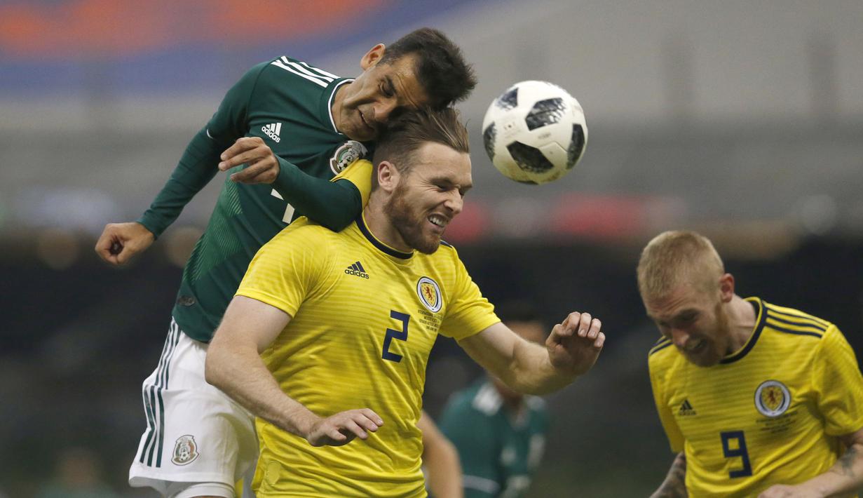Duel pemain Meksiko, Rafael Marquez (kiri) dengan pemain Skotlandia, Stephen O'Donnell (tengah) pada laga uji coba di Azteca Stadium, Meksiko City, (2/6/2018). Meksiko menang 1-0. (AP/Rebecca Blackwell)