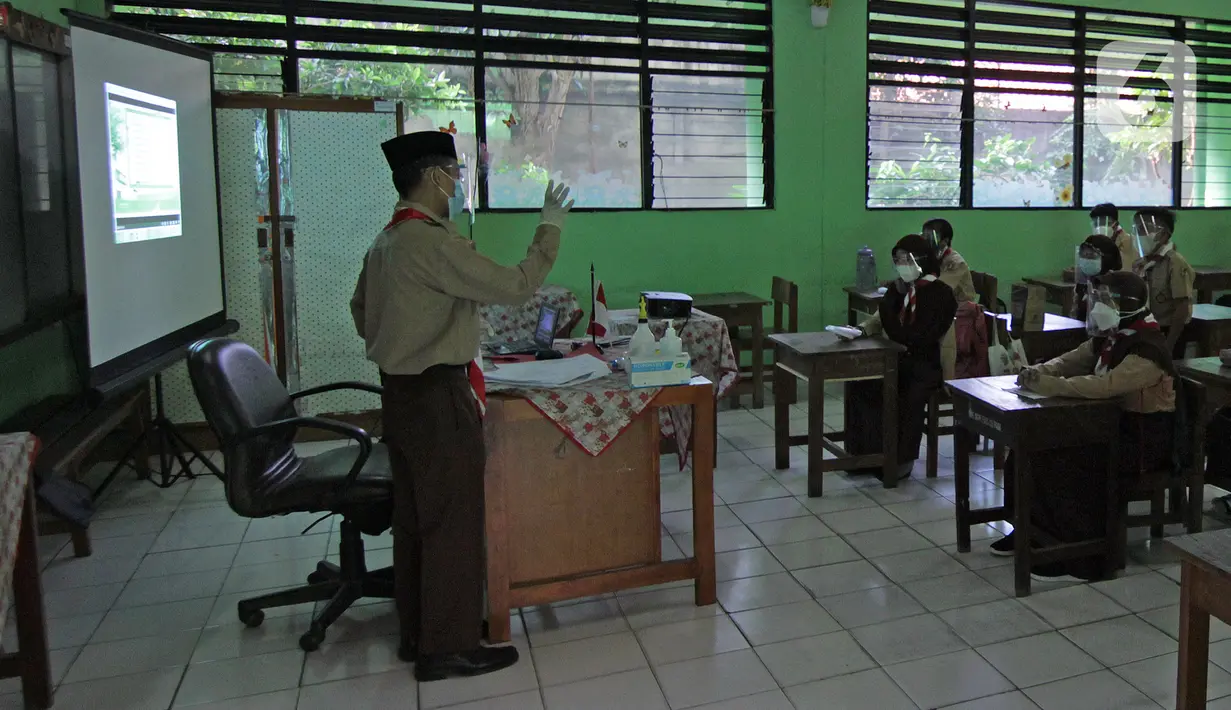 Guru mengajar siswa saat uji coba kegiatan belajar tatap muka di SDN Kenari 07/08 Pagi, Jakarta, Rabu (9/6/2021). SDN Kenari 07/08 Pagi telah menjalani evaluasi (assesment) dan dinilai telah memenuhi persyaratan untuk pembelajaran tatap muka sesuai protokol kesehatan. (Liputan6.com/Herman Zakharia)