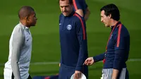Pelatih PSG, Unai Emery (kanan) berbincang dengan Kylian Mbappe saat latihan di Saint-Germain-en-Laye, Paris (26/9). PSG akan bertanding melawan Bayern Munchen pada grup B Liga Champions. (AFP Photo/Franck Fife)