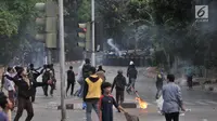 Pelajar bentrok dengan polisi saat berdemonstrasi di Jalan Layang Slipi, Petamburan, Jakarta, Rabu (25/9/2019). Bentrok pelajar dengan polisi yang terjadi sejak siang hingga malam tersebut dipicu kekerasan yang dialami pelajar saat demo di Gedung DPR. (merdeka.com/Iqbal Nugroho)