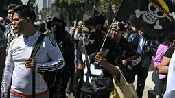 Ini adalah demonstrasi kedua yang bertujuan untuk memprotes kebijakan keamanan pemerintah sayap kiri. Tampak dalam foto, seorang pengunjuk rasa memegang bendera berlogo manga populer Jepang, One Piece, simbol yang diadopsi oleh gerakan protes Gen Z di seluruh dunia, dalam sebuah demonstrasi yang diserukan oleh Generasi Z untuk menentang pemerintahan Presiden Meksiko, Claudia Sheinbaum, di sepanjang Reforma Avenue di Mexico City pada 20 November 2025. (CARL DE SOUZA/AFP)