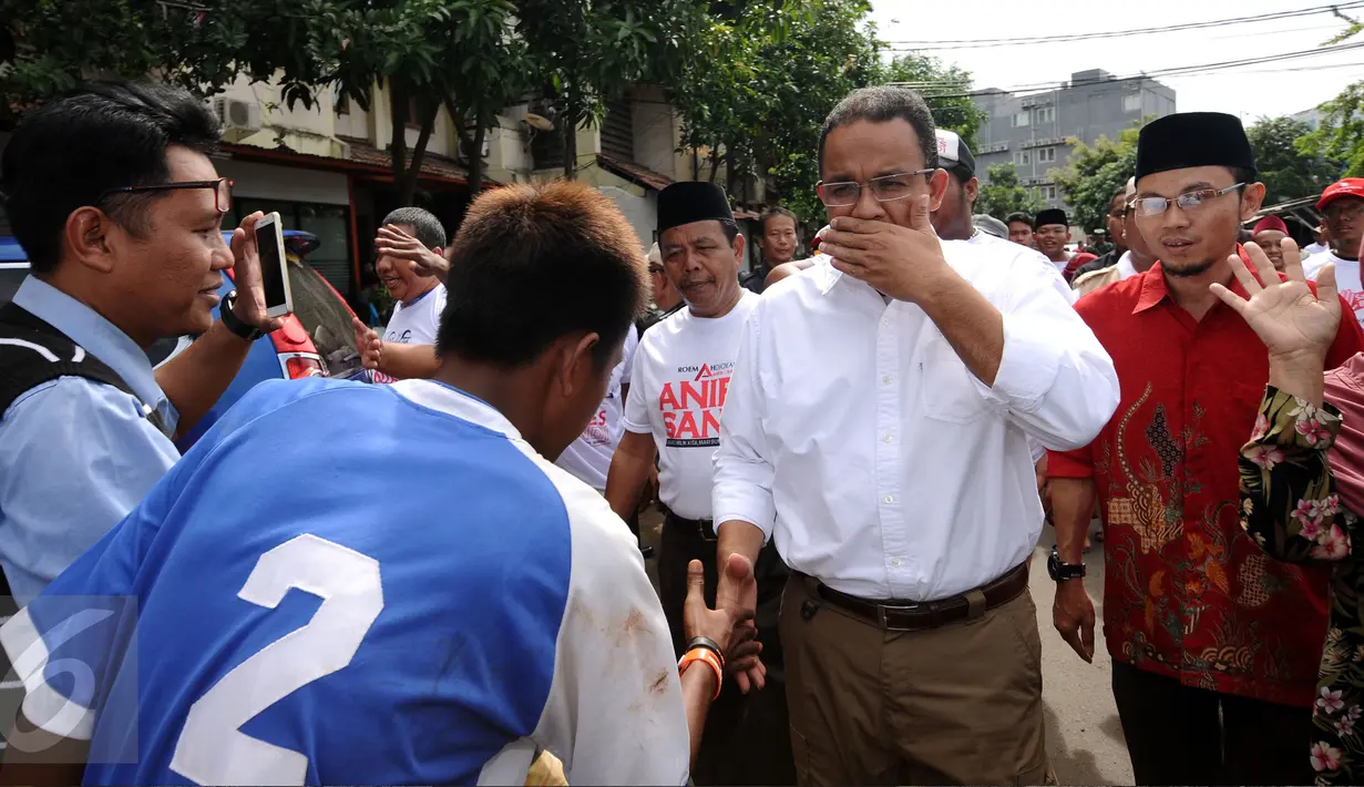 Cagub DKI Jakarta, Anies Baswedan (kedua kanan) menyalami warga jelang sosialisasi di Rusun Karet Tengsin, Jakarta, Rabu (28/12). Anies juga melantik koordinator tim pemenangan tingkat Rt dan Rw di Karet Tengsin. (Liputan6.com/Helmi Fithriansyah)