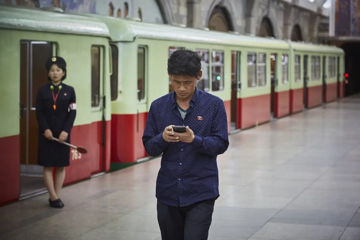 Seorang penduduk menggunakan smartphone di sebuah stasiun (Sumber: Nextshark)