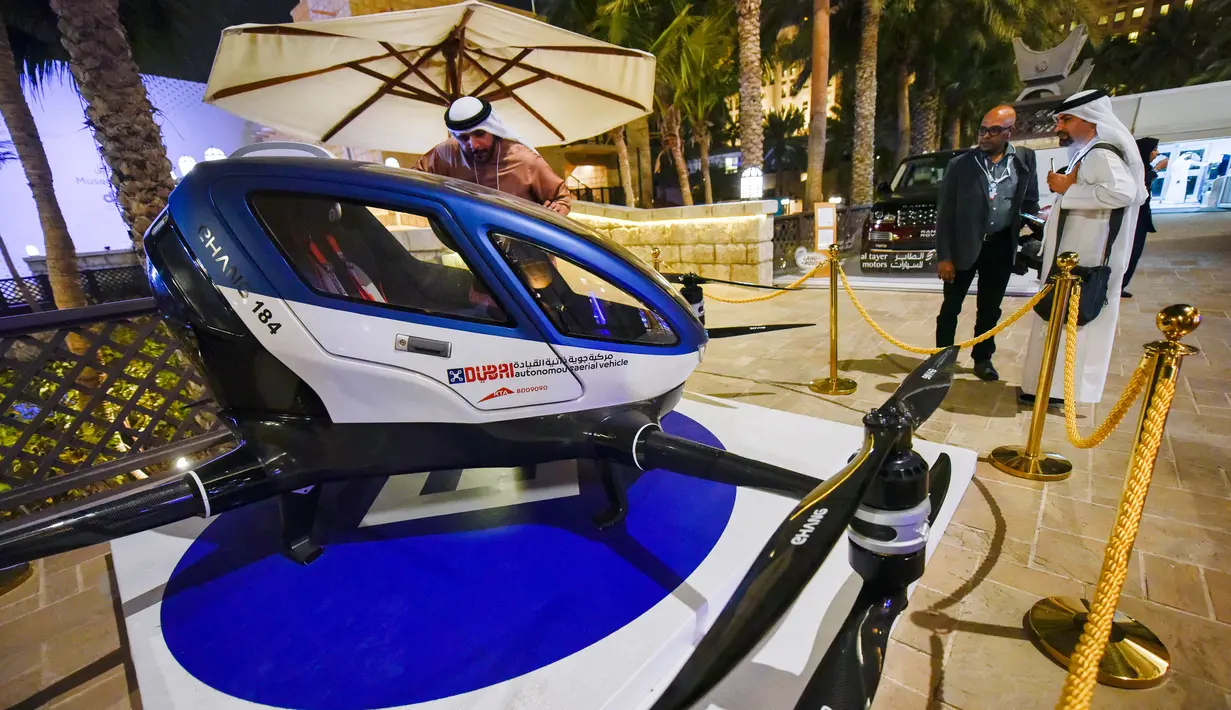 Pengunjung mengamati Drone EHang 184 yang dipamerkan di World Government Summit 2017, Dubai, Senin (13/2). Ehang 184 bentuknya menyerupai helikopter kecil dengan empat baling-baling yang mampu mengangkut beban hingga berat 100 kilogram. (STRINGER/AFP)