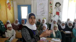 Omayma Al Hushan berbicara di hadapan rekan-rekannya di sebuah sekolah di Mafraq, Yordania (21/4). Meski berusia 14 tahun, Omayma sangat aktif menyerukan perlawanan terhadap pernikahan dini yang marak di Suriah. (21/4). (REUTERS / Muhammad Hamed)