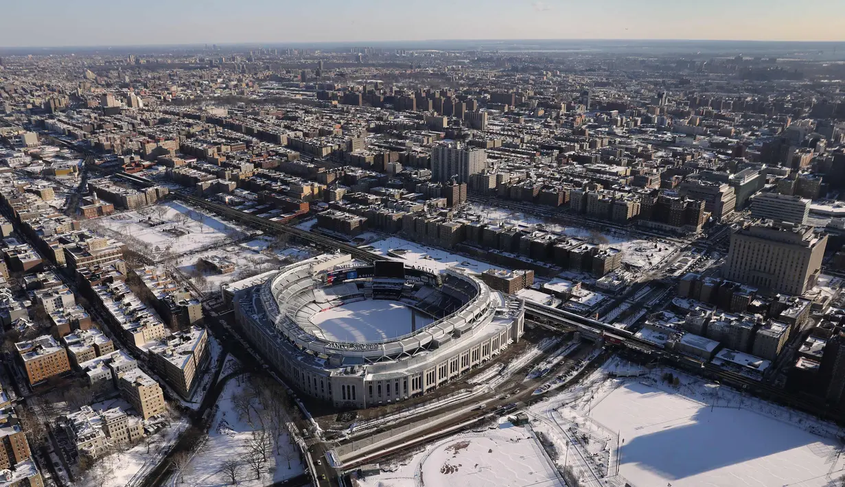 Stadion Yankee dan sekelilingnya memutih diselimuti salju di  Bronx Borough, New York City, Amerika Serikat,  (5/1). Cuaca ekstrem dan terpaan Topan Bom membuat wilayah AS diselimuti salju cukup tebal. (John Moore/AFP)